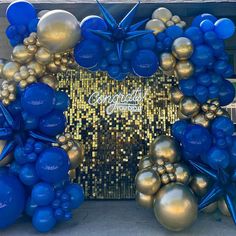 blue and gold balloons are in front of a golden wall with the words congratulations written on it