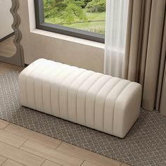 a white bench sitting on top of a hard wood floor next to a large window