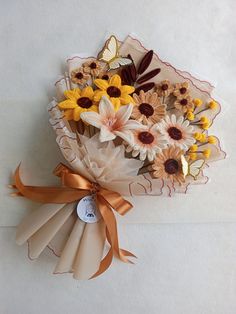 a bouquet of sunflowers and daisies wrapped in brown paper with a bow