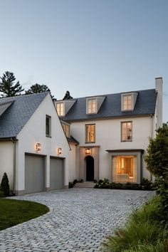 a large white house with lots of windows on the front and side of it's roof