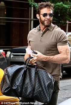 a man walking down the street carrying a black bag