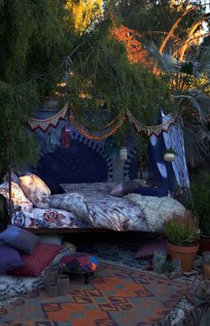 a bed sitting in the middle of a lush green forest