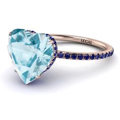 an aqua heart shaped ring with blue sapphires on the sides and white diamonds in the middle