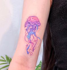 a woman's arm with a purple jellyfish tattoo on it