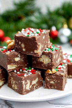 a white plate topped with chocolate fudges and christmas candy bar pieces on top of each other