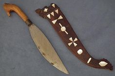 an old knife and wooden carving on a table