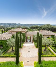 an aerial view of a house surrounded by hedges and trees