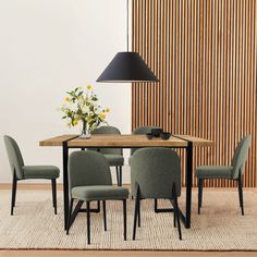 a dining room table with chairs and a lamp on the wall next to it in front of a wooden paneled wall