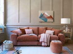 a living room with pink couches and rugs on the floor in front of a large window