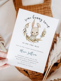 a person holding up a card with an image of a bunny in the center and some feathers