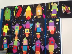 a bulletin board with colorful paper rockets and stars in the night sky on it's side