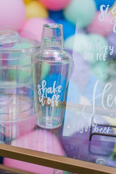 there is a glass bottle with the word shake me on it next to other plastic bottles