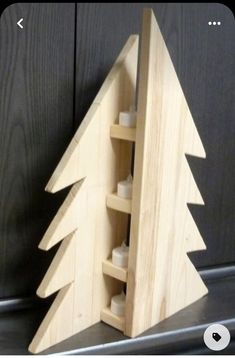 a wooden christmas tree with candles in it