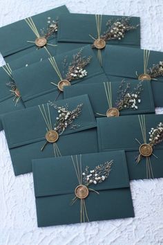 there are many cards that have flowers on them in the shape of envelopes with gold buttons