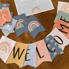 a wooden table topped with lots of colorful paper signs and magnets on top of it