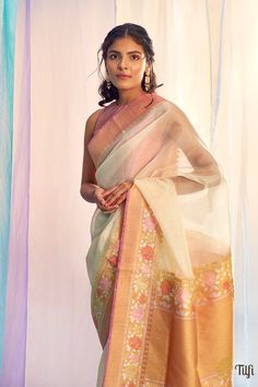 "\nSarala\nA\u00a0beautiful handwoven reminder of our rich and vibrant\u00a0heritage! A timeless shade adorned with stunning resham and intricate Meenakari detailing along the border and pallu, this is a Banarasi classic in gossamer kora silk.\u00a0\n\u00a0\n\n\nColour -\u00a0A classic shade of Off-White\u00a0\n\n Technique -\u00a0 Classic handwoven Banarasi Meenakari art passed down through generations. Meenakari involves the painstaking addition of supplementary\u00a0coloured threads during the\u00a0hand-weaving\u00a0process.\n\n Fabric - Light and airy,\u00a0pure Kora Silk\n\n Speciality - The beautiful resham, floral Meenakari work makes this a unique piece from Banaras. Woven in the finest banarasi weave in pure Kora Silk.\n\n Tilfi Promise - Pure. Handloom. Banaras.\nNote - The saree Saree Blouse Styles, Kora Silk Sarees, Latest Designer Sarees, Saree Designs Party Wear, Traditional Indian Outfits, Ethnic Looks, Designer Sarees Online, Elegant Saree, Stylish Sarees