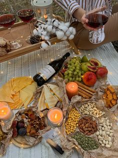 a woman sitting at a table filled with food and wine