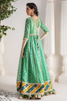 Make a colorful style statement with our beautifully crafted ensemble, gorgeous hand block printed kalidar, heavily embellished with sequins, beads and gota boti chan, neckline and sleeves are beautifully adorned with gorgeous zardozi work, stunning teal & Dhani green hued chata pati appliquéd border on hem finishes it beautifully, gorgeous detailed back and hand-made tassels gives entire outfit a trendy element. This stunning kalidar is offset with jamawar Lehanga and gorgeous Maysuri dupatta featuring gota motifs and heavily embellished chan, trimmed with gota borders , a Must- have wardrobe staple to carry all Wedding Festivities in effortless style. Kalidar Fabric: Pure Silk Net Lehanga Fabric: Jamawar Dupatta Fabric: Pure Maysuri Outfit Color: Opal This outfit is only available in Cus Navratri Chinon Kurta With Dabka Work, Navratri Dabka Work Kurta In Chinon, Navratri Dabka Work Chinon Kurta, Festive Chanderi Dress For Transitional Season, Green Resham Embroidered Anarkali Set In Mulmul, Traditional Drape Dress In Cotton Silk With Gota Work, Traditional Drape Cotton Silk Dress With Gota Work, Semi-stitched Raw Silk Dress With Gota Work, Anarkali Kurta With Resham Embroidery In Chinon