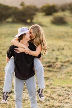 two people are hugging each other in the field