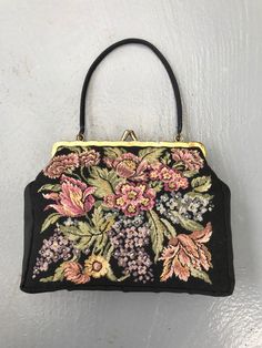 Black mini handbag with tapestry floral design on the front. Edges and clasp in gold satin lustre. Small black fabric handle. A stylish item for a night out or other occasion. A great gift for yourself or a close friend. Materials: no labels, front part is tapestry. MEASUREMENTS -  Length: 7.67 inches / 19.5 cm Height: 6.10 inches / 15.5 cm Depth: 1.18 inches / 3 cm CONDITION: Very good vintage condition. All measurements are taken with the garment lying flat. Due to lighting, the color of the p Vintage Tapestry Pouch Bag, Embroidered Satchel Evening Bag, Embroidered Evening Satchel Bag, Evening Embroidered Satchel Bag, Rectangular Gold Embroidery Evening Bags, Vintage Evening Bag In Tapestry Material, Vintage Tapestry Bag For Evening, Evening Tapestry Rectangular Shoulder Bag, Evening Rectangular Tapestry Shoulder Bag