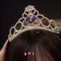 a woman wearing a tiara with purple stones on it