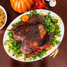 two plates with food on them sitting on a table next to pumpkins and gourds