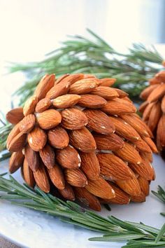 two pine cones sitting next to each other on top of a white tablecloth covered surface