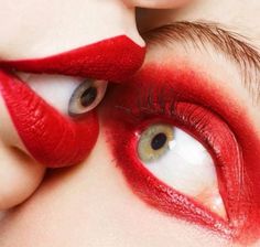 two women with red lipstick on their faces and one woman's eye is open