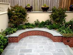 an outdoor patio with brick walls and planters