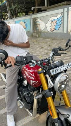 a man sitting on top of a red motorcycle