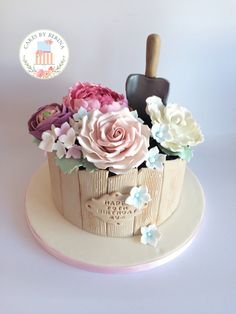 there is a cake with flowers in the basket on the top and an ice cream scoop next to it