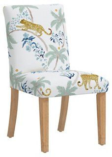 an upholstered chair with leopards and palm trees on the back, against a white background