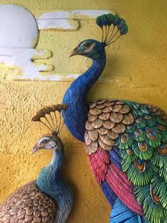 two peacocks are standing next to each other on a yellow and yellow wall,