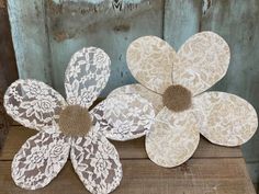 three paper flowers sitting on top of a wooden table