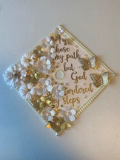 a graduation cap with butterflies and pearls on the side that says, i choose my path but god ordered my steps