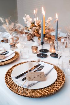 a table set with place settings and candles