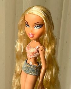 a close up of a barbie doll with blonde hair and blue jeans on her pants