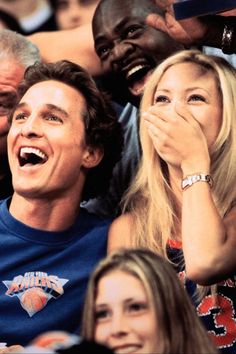 a man and woman sitting next to each other at a basketball game with their mouths open