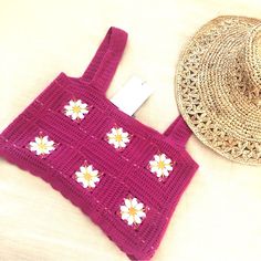 a crocheted purse and straw hat on a bed