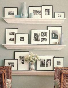 two shelves with pictures and vases on them