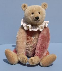 a brown teddy bear sitting on top of a blue surface