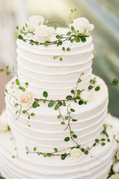 a wedding cake with white flowers and greenery