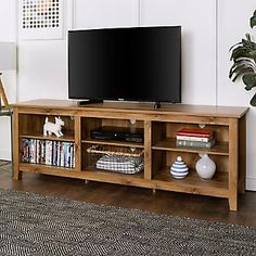 a flat screen tv sitting on top of a wooden entertainment center in a living room