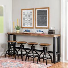 three stools are sitting in front of a table with two pictures on the wall