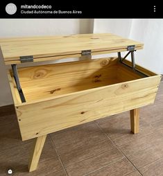 a wooden table with an open drawer on it's side, sitting on tile flooring