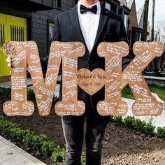 a man in a tuxedo holding up a sign that says mr and mrs