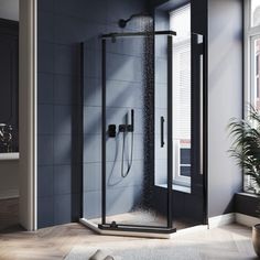 an open shower stall in a bathroom next to a potted plant on the floor