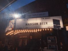 the marquee sign for madison beer is lit up at night with lights on