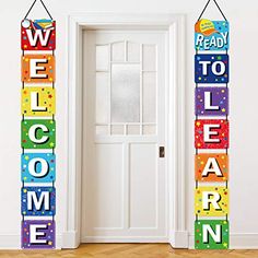 two colorful welcome signs hanging from the side of a door