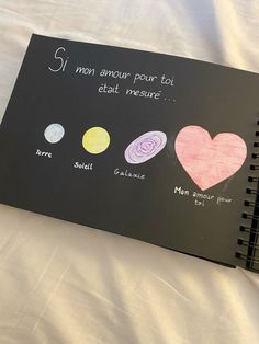 a black notebook with writing on it that has pictures of different planets and their names